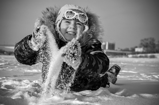 Фото сделано зимой в 2017 году. Беззаботное детство. Ребенок играет играет в снегу и веселиться.